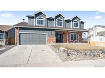 Charming two-story home featuring a two-car garage, a cozy front porch, and well-maintained landscaping at 5547 S Urban St, Littleton, CO 80127