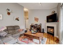 Comfortable living room with wood floors, cozy fireplace, and an artistic decorative style at 8422 S Upham Way # H75, Littleton, CO 80128
