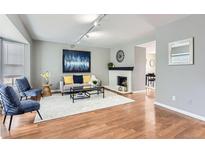 Bright living room with hardwood floors, fireplace, and neutral paint, perfect for entertaining guests at 7114 E Briarwood Dr, Centennial, CO 80112