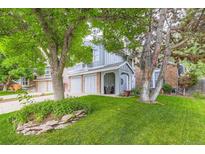Charming home with a well-manicured lawn, mature trees, and a cozy covered front porch at 10360 Irving Ct, Westminster, CO 80031