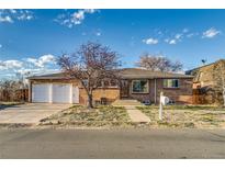 Brick front ranch home with an attached two-car garage and a concrete walk way up to the front door at 6095 W 47Th Ave, Wheat Ridge, CO 80033