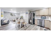 Open-concept living area with a dining table, stainless steel appliances, and a stylish stone accent wall at 8826 E Florida Ave # G12, Denver, CO 80247