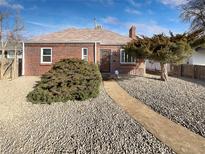 Charming brick home featuring low maintenance front yard landscaping and a concrete walkway leading to the front door at 1648 Quebec St, Denver, CO 80220