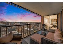 Spacious balcony featuring outdoor seating and grill, offering stunning city views and vibrant sunset colors at 1551 Larimer St # 2602, Denver, CO 80202