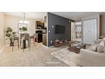 Bright living room featuring a modern gray accent wall and a kitchen/dining area with a round table at 3009 Madison Ave # K317, Boulder, CO 80303