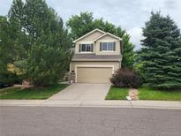 Charming two-story home featuring a two-car garage and lovely curb appeal with mature trees at 10386 Ravenswood Way, Highlands Ranch, CO 80130