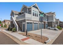 Attractive townhome with stone accents, multiple garages, and a welcoming stairway to upper-level unit at 5755 S Buchanan Ct # E, Aurora, CO 80016