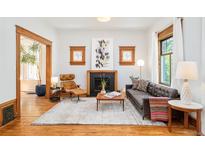Bright living room features hardwood floors, fireplace, and large windows for natural light at 2228 N Race St, Denver, CO 80205