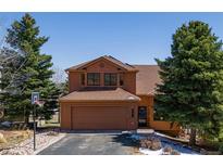 Charming two-story home with attached garage, basketball hoop, and mature trees at 783 Calgary Way, Golden, CO 80401