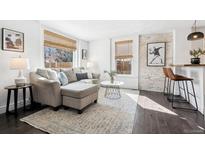 Bright living room with hardwood floors, large windows, and comfortable seating arrangement at 1535 Spruce St, Denver, CO 80220