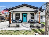 Charming home with a quaint front porch, complete with seating and patriotic flags at 8885 W 64Th Pl, Arvada, CO 80004
