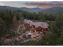 Stunning mountain home featuring a stone patio, water feature, and lush landscaping at 2929 Highlands View Rd, Evergreen, CO 80439