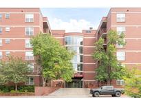 An exterior shot of a brick apartment building with well-maintained landscaping at 5955 E 10Th Ave # 507, Denver, CO 80220