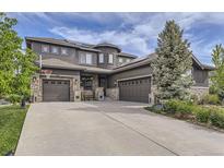Beautiful home with a three-car garage, stone accents, and mature landscaping at 1495 W 137Th Ave, Broomfield, CO 80023