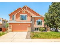 Charming two-story home featuring a well-maintained lawn, attached two-car garage and inviting facade at 19595 Mitchell Dr, Denver, CO 80249
