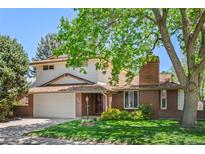 Charming two-story home with a brick facade, mature trees, and well-maintained lawn at 1844 S Pontiac Way, Denver, CO 80224