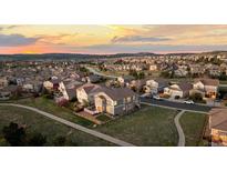 Stunning aerial view of the neighborhood at sunset, showcasing the home, streets and surrounding landscape at 1983 Candleglow St, Castle Rock, CO 80109