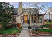 Charming brick home featuring a well-maintained yard with mature trees and colorful landscaping at 510 16Th St, Golden, CO 80401