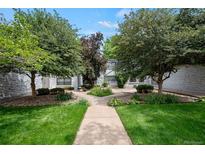 Charming home with a well-manicured lawn, mature trees, and a stone facade at 5751 E Ithaca Pl # 3, Denver, CO 80237