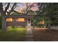 Charming brick home with manicured lawn, mature trees and a welcoming front porch at 7034 S Cherry St, Centennial, CO 80122