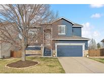 Charming two-story home with a blue exterior, stone accents, and a well-manicured lawn at 684 Poppy Pl, Highlands Ranch, CO 80129