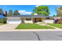 Charming brick home with a well-maintained lawn and attached two-car garage under a clear blue sky at 3375 Zephyr Ct, Wheat Ridge, CO 80033