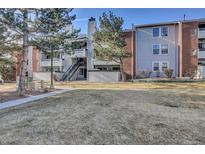 Attractive condo building featuring manicured lawn and beautiful facade with balconies and a staircase at 14467 E 1St Dr # A04, Aurora, CO 80011
