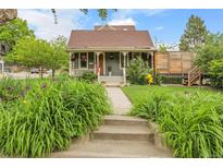 Charming front yard with lush greenery, flower beds, and a cozy porch with patriotic accents at 503 15Th St, Golden, CO 80401
