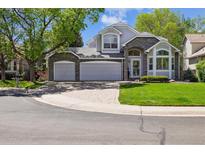 Charming home with stone accents, a three-car garage, and a well-manicured lawn at 14186 E Hampden Pl, Aurora, CO 80014