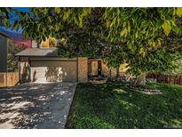 Charming home with a two-car garage, a lush green lawn, and a mature tree offering shade at 3647 S Uravan St, Aurora, CO 80013