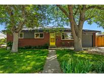Charming brick home with a well-maintained lawn and a welcoming yellow front door at 6088 Quail Ct, Arvada, CO 80004
