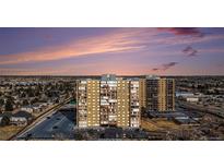 Stunning exterior view of a brick apartment building with a parking lot during sunset at 7865 E Mississippi Ave # 1102, Denver, CO 80247