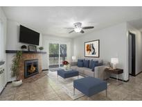 Inviting living room featuring a cozy fireplace, ceiling fan and access to the balcony at 14590 E 2Nd Ave # B309, Aurora, CO 80011