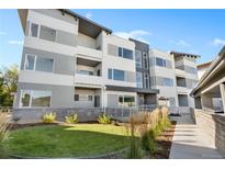 Modern condo building with a landscaped lawn area and accessible ramp entrance under a sunny blue sky at 1308 Snowberry Ln # 303, Louisville, CO 80027