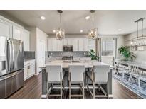 Modern kitchen with stainless steel appliances, granite counters, island and hardwood floors at 17382 Bluetrail Ave, Parker, CO 80134
