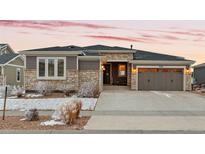 Charming single-Gathering home featuring stone accents, neutral colors, and a spacious three-car garage at 9388 Dunraven Loop, Arvada, CO 80007