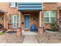 Charming brick townhome exterior featuring a blue front door and cozy porch seating at 19 S Harrison St, Denver, CO 80209