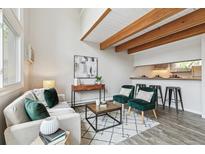Bright living room boasts wood beams, accent chairs, and easy kitchen access at 1842 Canyon Blvd # 209, Boulder, CO 80302
