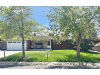 Charming brick home with a well-manicured lawn and mature trees in a tranquil neighborhood at 13024 E Alaska Pl, Aurora, CO 80012