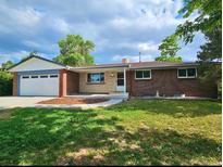 Charming brick home with a well-maintained lawn and attached two-car garage at 13024 E Alaska Pl, Aurora, CO 80012