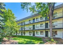 Three-story apartment building with black iron railings and lush greenery in a well-maintained yard at 5995 E Iliff Ave # 106, Denver, CO 80222