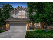 Charming two-story home with a well-manicured lawn, mature trees, and a two-car garage at 10707 Jordan Ct, Parker, CO 80134