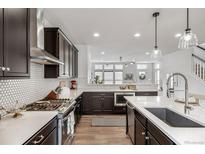 Gourmet kitchen features stainless steel appliances and white backsplash, perfect for cooking and entertaining at 11027 Sunshimmer Cir, Parker, CO 80134