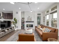 Bright living room with a modern fireplace and stylish leather furniture at 11027 Sunshimmer Cir, Parker, CO 80134