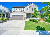 Charming two-story home featuring a well-manicured lawn, a two-car garage, and classic architectural details at 834 Bear Peak Rd, Erie, CO 80516