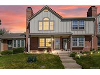 Charming two-story home with a brick facade, complemented by a well-manicured lawn and inviting front porch under an orange sunset at 9676 W Chatfield Ave # B, Littleton, CO 80128