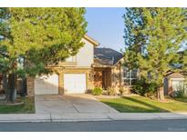 Charming two-story home with brick accents, attached two-car garage, and mature landscaping at 10961 Main Range Trl, Littleton, CO 80127