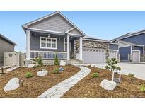 Charming home featuring a welcoming porch and a professionally landscaped front yard with stone walkway and stylish accents at 6711 Fraser Cir, Frederick, CO 80530