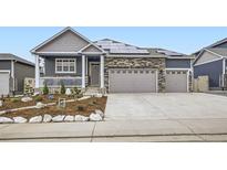 Charming home featuring stone accents, solar panels and a spacious three car garage at 6711 Fraser Cir, Frederick, CO 80530