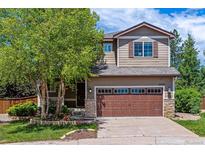 Charming two-story home featuring well-maintained landscaping, a two-car garage and a beautiful tree in the front yard at 10358 Kelliwood Way, Highlands Ranch, CO 80126
